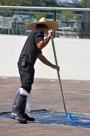 BRISBANE, AUS - SEP 25 2014:Swimming pool service technician clean a pool. there are about...