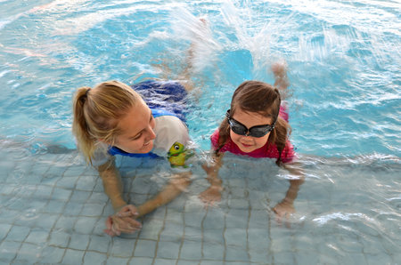 GOLD COAST - OCT 15 2014:Swimming trainer during child (Talya Ben-Ari age 04) swimming pool lesson.Children who have an early swimming experience show improved physical and mental development.のeditorial素材