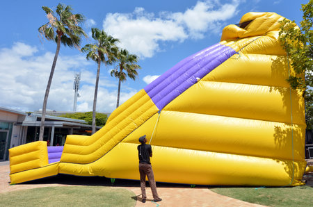 GOLD COAST - OCT 19 2014:Worker inflate slide bouncy Castle.In 2001 U.S. Consumer Product Safety Commission outline the dangers and recommended safety precautions for operating an inflatable structureのeditorial素材