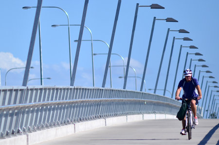 GOLD COAST, AUS - OCT 13 2014:Man rid a bike over Sundale BridgeThe bridge span across the Nerang River in Southport Gold Coast Queensland Australia.のeditorial素材