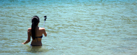 SURFERS PARADISE, AUS - NOV 09 2014:Woman take selfie photo on the beach. Over 1 Million selfies Are taken each day.Instagram has over 53 million photos tagged with the hash tag #selfie.のeditorial素材