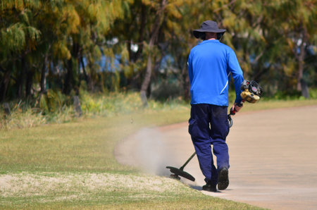 GOLD COAST, AUS - OCT 16 2014:Worker cutting grass.According to the 2010 National Gardening...