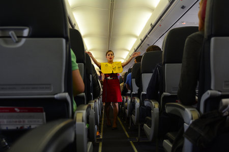 Photo pour AUCKLAND - SEP 22 2014:Flight attendant. For planes with up to 19 passenger seats, no flight attendant is needed. For larger planes, one flight attendant per 50 passenger seats is needed. - image libre de droit