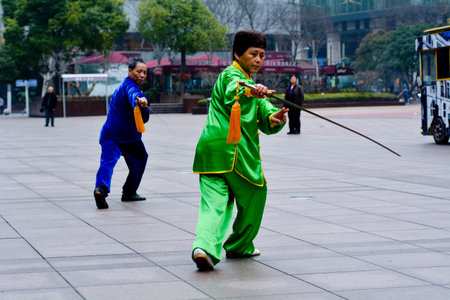 SHANGHAI, CN - MAR 17 2015:Chinese couple practice Tai Chi in Nanjing Road Shanghai China.It is an internal Chinese martial art practised for both its defense training and its health benefits.のeditorial素材