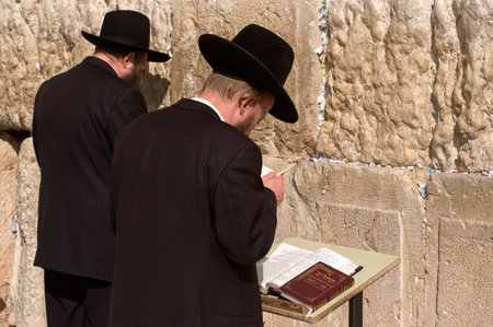 JERUSALEM - AUGUST 11:Jewish men are praying at the western wall on August 11 2005 in Jerusalem, Israel.It is a remnant of the ancient wall that surrounded the Jewish Temple's and is the most sacred site recognized by the Jewish faith outside of the Templのeditorial素材
