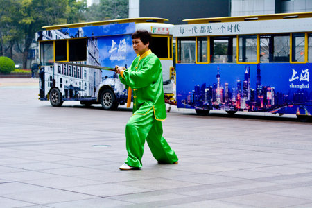 SHANGHAI, CN - MAR 17 2015:Chinese woman practice Tai Chi in Nanjing Road Shanghai China.It is an internal Chinese martial art practised for both its defense training and its health benefits.のeditorial素材
