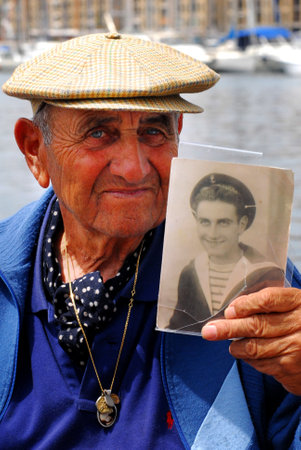 MARSEILLE - MAY 09:An old franch man shows his portrait as a young sailor on May 09 2008 in Marseille,France.Marseille is France's largest city on the Mediterranean coast and largest commercial port.のeditorial素材