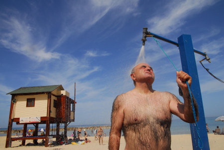 ASHKELON,ISR - MAR 22:Israeli man washing in cold water in outdoor shower on March 22 2008.Acording to Israel Meteorology Service the highest temperature ever recorded was 54C, at Tirat Tzvi 1942.のeditorial素材