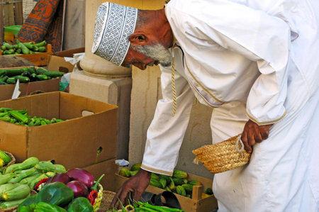 NIZWA, OMAN - DEC 28 2007:Omani man buy vegetables at the traditional agriculture market in Nizwa, Oman.It's a famous tourist sight seen in Nizwa, Oman.のeditorial素材