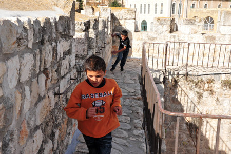JERUSALEM - NOV 05:Arab boys runs on Jerusalem old city walls on November 05 2010.The walls were built between the years 15351538, during the reign of the Ottoman empire by Sultan Suleiman the Magnificent.のeditorial素材