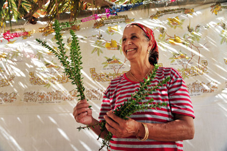 NETIVOT - OCTOBER 02: Israeli Jewish woman  happy in here Sukkah on the eve of the Jewish holiday Sukkoth on October 02, 2009 in Netivot, Israel.のeditorial素材