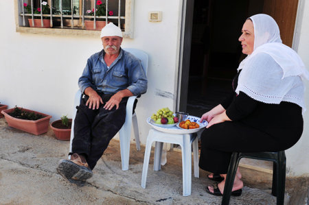 MAJDAL SHAMS - AUGUST 23:A Druze  husband and wife sit outside their front door in Majdal Shams,Israel on August 23 2009.The number of Druze people worldwide exceeds one million, with the vast majority residing in the Middle East.のeditorial素材