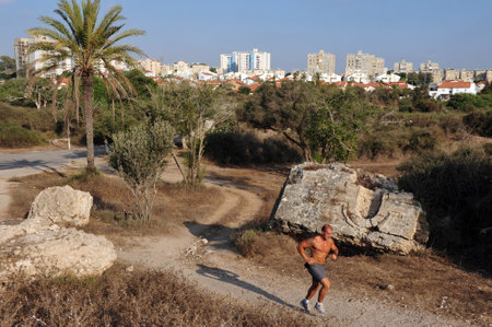 ASHKELON, ISR - JULY 23:Israeli man runs in Ashkelon National Park on July 23 2009.Ashkelon National Park, on the southern Mediterranean coast, encompasses history and heritage thousands of years old.のeditorial素材