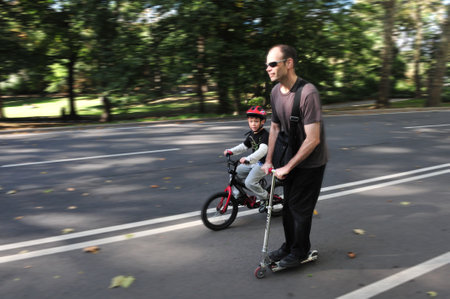NY - OCT 10: Father and his son cycles together in Central Park on October 10 2009 in Manhattan New York. Central Park is one of the world's largest urban public parks.のeditorial素材