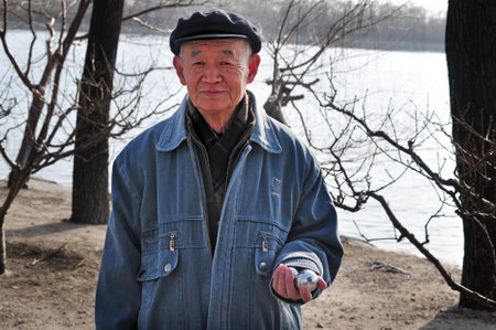 BEIJING - MAR 14:Chinese man exercise with Baoding balls in Beijing, China on March 14 2009.Baoding balls good to improve manual dexterity and strength and to assist in injury recovery.のeditorial素材