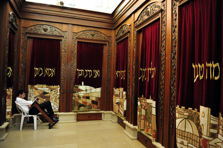 JERUSALEM - JULY 30: An Israeli Jewish orthodox man prays in a synagogue, reads a torah book (siddur) and wears, tefillin, tzitzit and tallit on July 30 2009 in Jerusalem, Israel.のeditorial素材