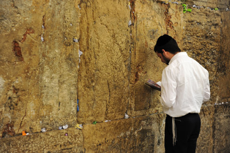 JERUSALEM -JULY 30: Jewish man is praying at the western wall on July 30 2009 in Jerusalem, Israel.It is a remnant of the ancient wall that surrounded the Jewish Temple's and is the most sacred site recognized by the Jewish faith outside of the Temple Mouのeditorial素材