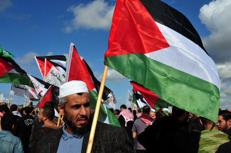 EREZ CROSSING - DECEMBER 31:A large group of Palestinian Arabs carry Palestinian flags during a protest on the Gaza-Israel border on December 31 2009.The entire  Palestinian population in Gaza Strip is 1.6 million people.のeditorial素材