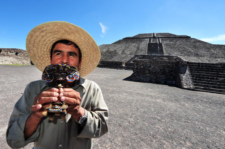 TEOTIHUCAN - FEB 26: Mexican man play music under the Sun Pyramid on february 26 2010 in Teotihuacan, Mexico.It's the third largest pyramid in the world (738 feet/225m across and 246 feet/75m high)のeditorial素材