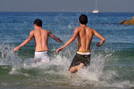 ASHDOD - JAN 09:Young Israeli man runs to the sea on a very hot day on Jan 09 2010.The highest recorded temperatures in Israel was 129 Fahrenheit  Degrees (54 Celsius) in Tirat Tsvi on June 21 1942.のeditorial素材