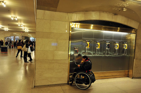 NY - OCT 14:Disabled man sit on a wheelchair and talks on a pay phoneat the Grand Central Station Manhattan on October 14 2009 in Manhattan New York, USA.Grand Central Terminal turns 100 in 2013のeditorial素材