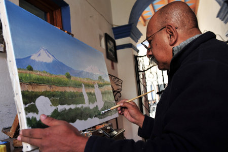 PUEBLA - FEB 25:Mexican artist painting the Popocatepetl and IztaccÃ­huatl Volcano Mountains on Feb 25 2010 in Puebla, Mexico.The translation of the names are: "Smoking Mountain" and "white woman"のeditorial素材