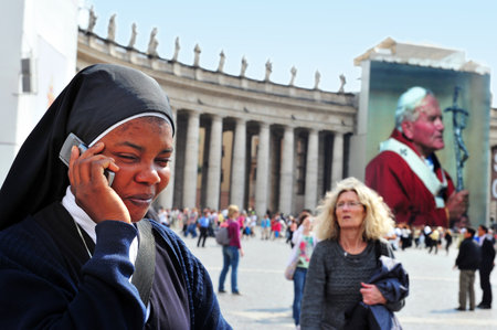 VATICAN - April 28:Black Catholic nun use here mobile at St Peter's basilica on April 28 2011 Vatican city in Rome Italy.Every Sunday at noon the Pope's blessing from his window at St Peter's basilica.のeditorial素材