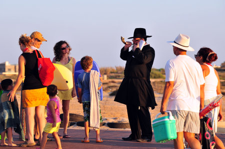 ASHDOD - SEPTEMBER 09: Jewish orthodox man Blows the shofar during the Jewish ceremony of Tashlich to begin the Jewish new year on September 9 2010 in Ashdod, Israel.のeditorial素材