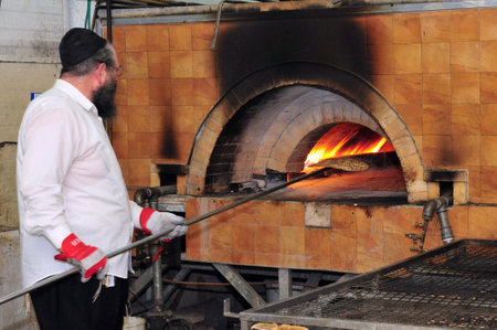 Orthodox Jewish men are prepare hand-made glat kosher matzah at Kisse Rahamim Matzot Factory in Moshav Brichia, southern Israel. Passover is a Jewish holy day and festival commemorating the Exodus from Egypt and the liberation of the Israelites from slaveのeditorial素材