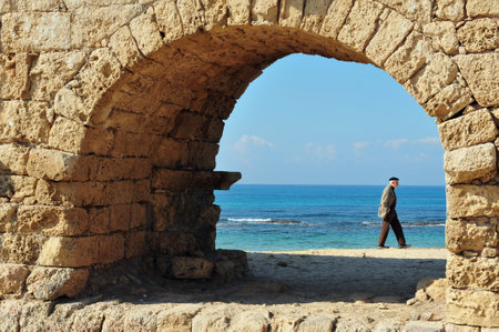 CAESAREA - DEC 13:Visitor at the ancient Roman aqueduct at Ceasarea on Dec 13 2009. The ancient Caesarea Maritima city and harbor was built by Herod the Great about 25â13 BCE.のeditorial素材