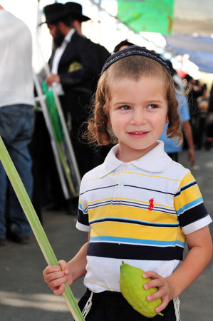 ASHDOD - OCTOBER 12 : Jewish ultra-orthodox  child holds Etrog and Lulav at a four species market for the Jewish holiday of Sukkot on October 12 2011 in Ashdod,Israel.のeditorial素材