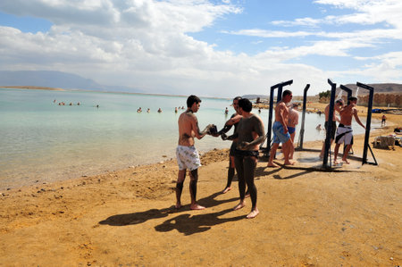 DEAD SEA, ISR - MAR 18:Young people in a bathing suit enjoys natural mineral mud on March  18 2010.The Dead Sea is filled with minerals including calcium, iodine, saline, potassium, and bromide.のeditorial素材