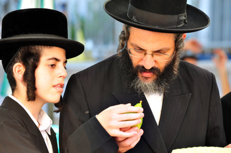 ASHDOD - OCTOBER 12 : Jewish ultra-orthodox  father and son inspect Etrog at a four species market for the Jewish holiday of Sukkot on October 12 2011 in Ashdod,Israel.のeditorial素材