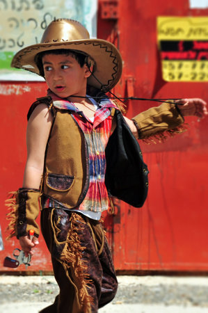 ASHKELON - MARCH 18: Israeli boy dressed up with cowboy costume during the Jewish holiday Purim on March 18 2011 in kindergarden in Ashkelon Israel.のeditorial素材