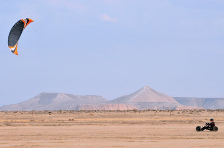 SDE BOKER - APRIL 04:A paraglider with a trike buggy is paragliding on April 04 2011 over the Negev desert, Israel.The speed achieved in kite buggies by skilled drivers can range up to around 110 km/h (70 mph).のeditorial素材