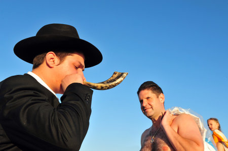 ASHDOD - SEPTEMBER 09: Jewish orthodox man Blows the shofar during the Jewish ceremony of Tashlich to begin the Jewish new year on September 9 2010 in Ashdod, Israel.のeditorial素材