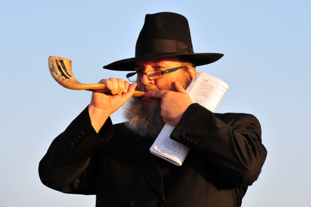 ASHDOD - SEPTEMBER 09: Jewish orthodox man Blows the shofar during the Jewish ceremony of Tashlich to begin the Jewish new year on September 9 2010 in Ashdod, Israel.のeditorial素材