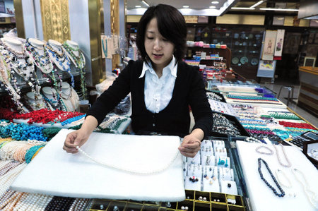 BEIJING -MARCH 14:Chinese woman sales pearl necklace at Beijing Pearl market on Mar 14 in Beijing, China.It's a famous mega-market that attracts many tourists looking for China's well known pearls.のeditorial素材