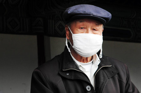 BEIJING-MARCH 15:Chinese man wear surgical masks on Mar 15 2009 in Beijing, China.In Asia its common to wear masks if person is sick in courtesy to prevent spreading their own infection to others.のeditorial素材