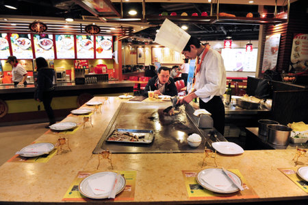 BEIJING - MARCH 12:Chinese chef in open mall restaurant on March 12 2009 in Beijing, China.Millions of chinese people eat street food every day.のeditorial素材