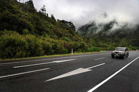 HANMER,NZ - MAR 15:Car drive on empty road on Mar 15 2009 near Hanmer,New Zealand.The distance from the top of the North Island to the bottom of the South Island is 1,930 km 1,200 miのeditorial素材