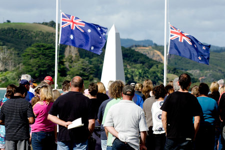 Crowd of people under the national flags of Australia and New Zealand during a National War Memorial Anzac Day services in New Zealand.のeditorial素材