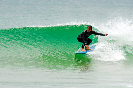 HENDERSON BAY - JAN 20: An old man wave surfing in Henderson Bay on January 20 2013.It's a beach break on a sandy beach on the Aupouri Peninsula, at the very top of the North Island in New Zealand.のeditorial素材