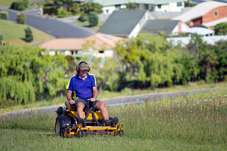 CABLE BAY - NOV 04:Man rides on lawn mower on Nov 04 2013.The first mechanical grass-cutting device appeared in 1830 by English textile worker named Edwin Budding from England.のeditorial素材