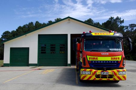 A city fire station - doors open and fire trucks waiting.