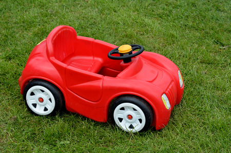 Red sport toy car outdoor on a green grass. copyspace