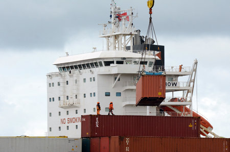 AUCKLAND,  NZL -OCT 13 2015:Cargo ship workers unloading containers in Ports of Auckland New...