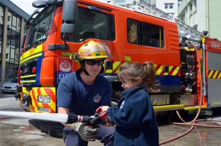 AUCKLAND  - OCT 27 2015:Firefighter and child Talya Ben-Ari age 05 during Fire Safety Education day.Each year over 20,000 fires are attended by New Zealand Fire Service with about 5,000 house fires.のeditorial素材