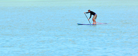 CHRISTCHURCH - DEC 04 2015:Man paddle boarding.A 2013 report identified Standup paddleboarding as the outdoor sporting activity with the most first-time participants of any in the United States.のeditorial素材