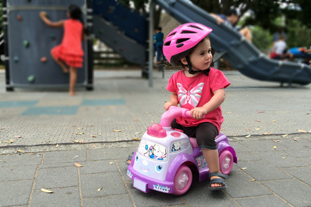 Little girl (age 1-2) riding toy car in the playground. Childhood conceptの写真素材
